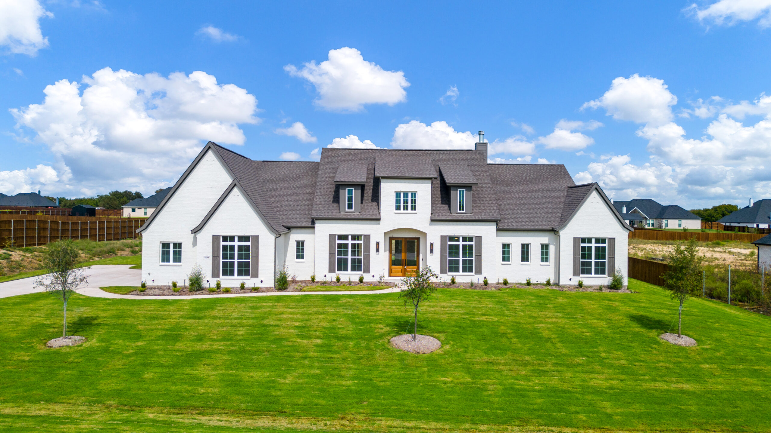 Front elevation of a new white farmhouse-style home