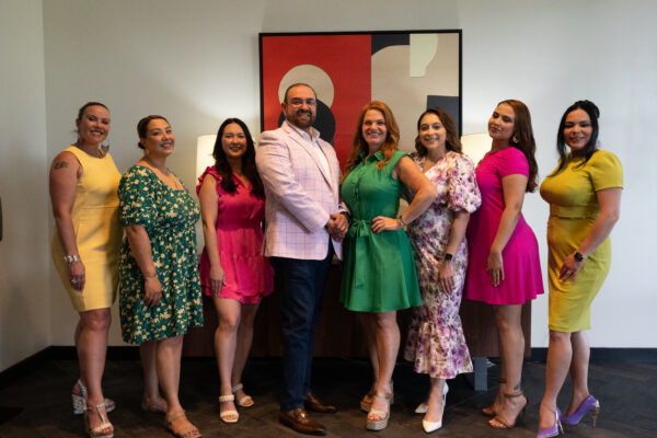 Team photo of ten agents in front of a modern painting