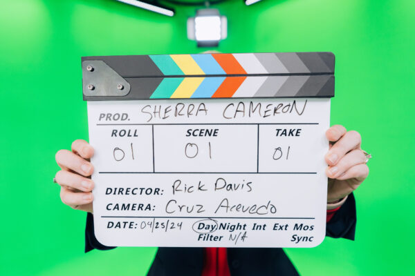 Clapperboard held up before a green screen take