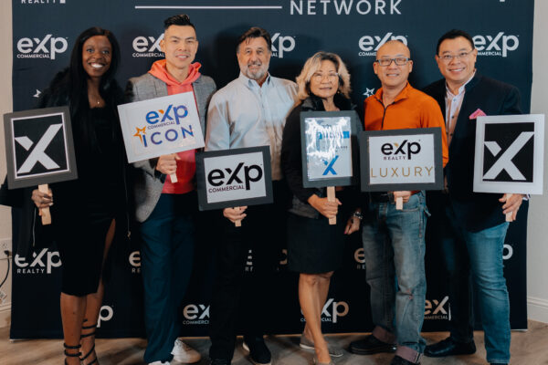 Group photo at a real estate brokerage event backdrop