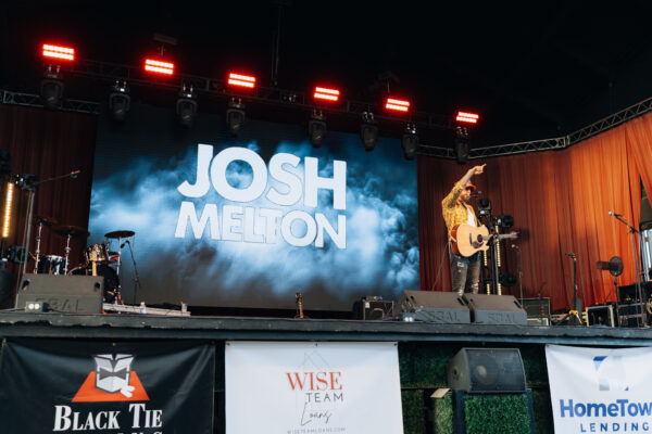 Musician performing on stage at a sponsored concert