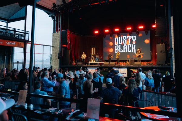 Country band performing on an outdoor stage in front of a crowd