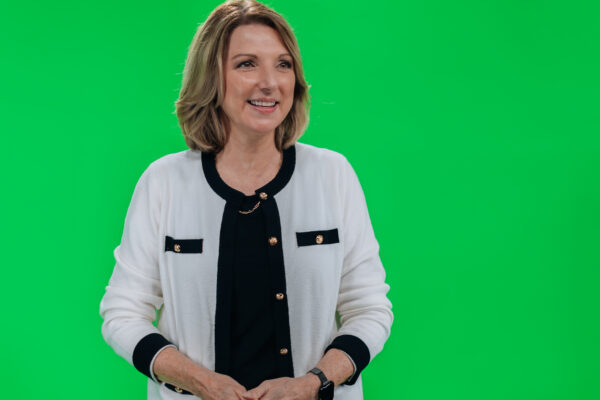 Woman in a white jacket on the green screen stage