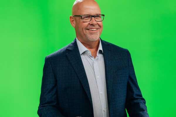 Smiling man in a blazer on the green screen stage