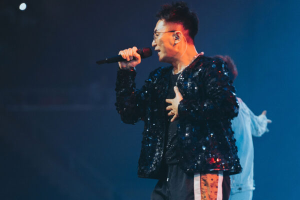 Singer performing on stage under blue lights