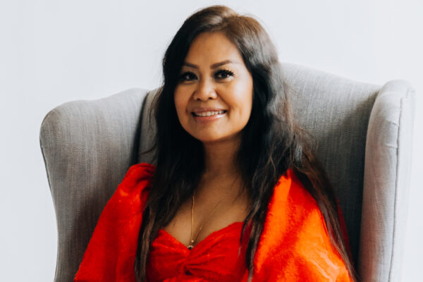 Branding portrait of a woman in a red dress seated in an armchair