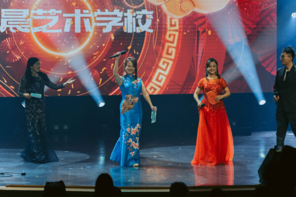 Performers in traditional dresses on stage at a cultural event