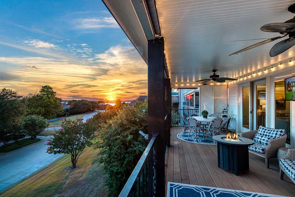 Covered back patio at sunset with outdoor seating and fire table