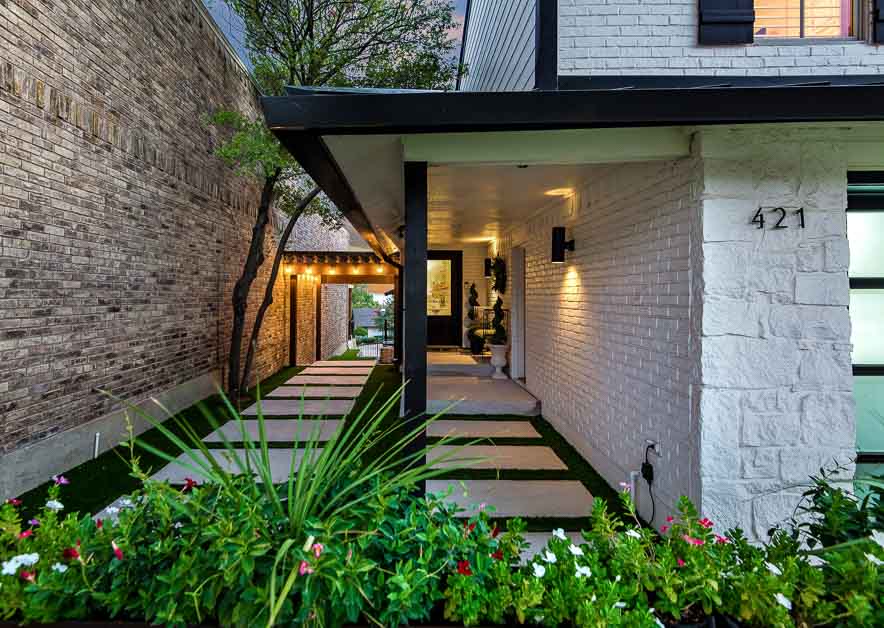Modern home entry with a lit stone walkway