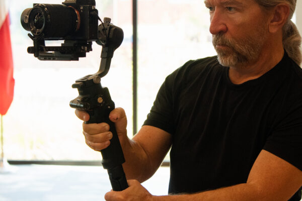 Videographer operating a camera on a handheld gimbal