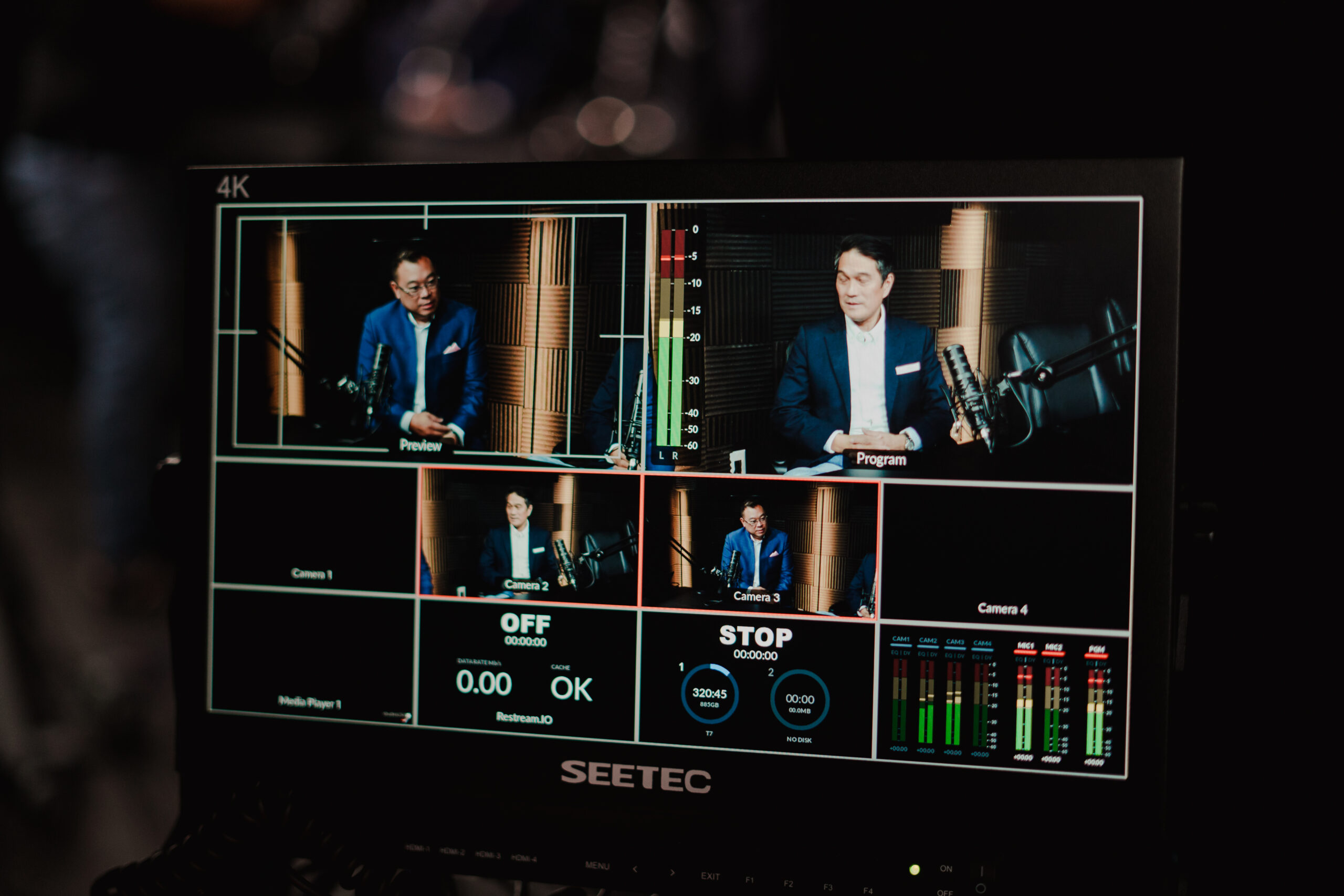 Live switcher monitor showing four camera angles of a two-person interview