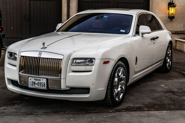 White luxury sedan parked in front of a garage