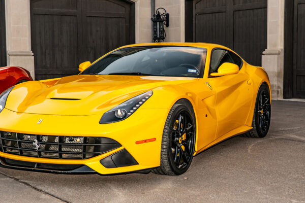 Yellow sports car parked in front of a garage