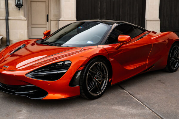 Orange supercar parked in front of a garage